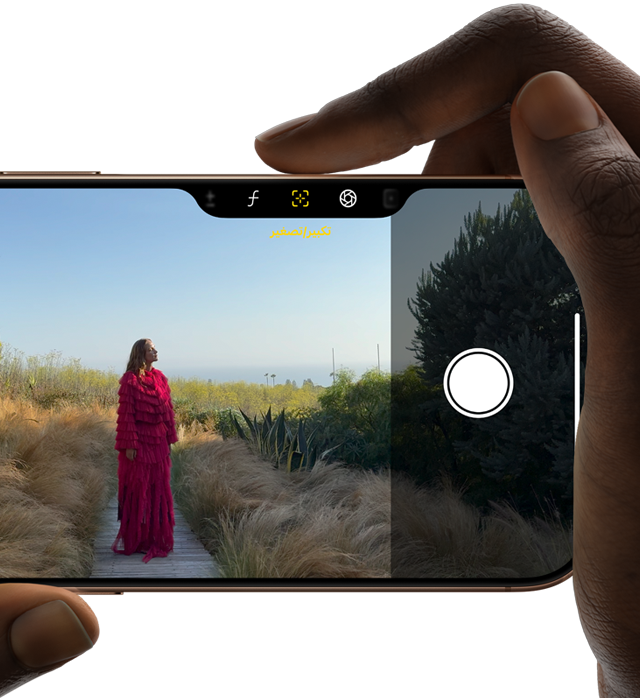 التحكم في الكاميرا على iPhone 16 Pro، إصبع اليد اليمنى ينزلق على جانب الهاتف لضبط عمق المجال